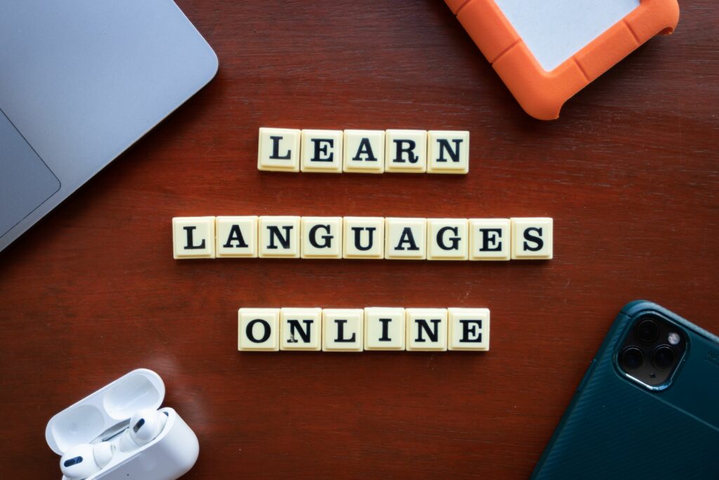 pexels photo 14814060 14814060 Flat lay of language learning tools with devices and text blocks on desk.